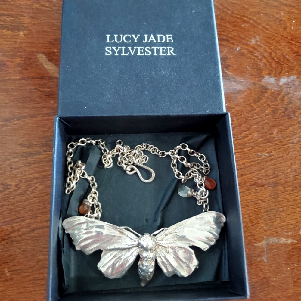 This is a solid sterling silver necklace of a hawk moth with crystals.